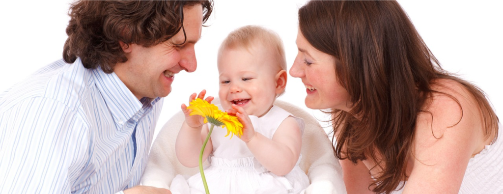 padre, madre e hija sonreindo