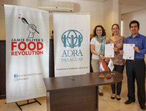 Representantes de ADRA Paraguay, Javier Espejo, junto a las representantes de Food Revolution, luego de la firma del convenio. 