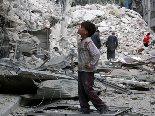 A boy inspects a damaged site after airstrikes on the rebel held Tariq al-Bab neighbourhood of Aleppo