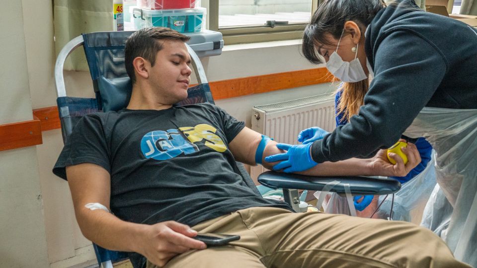 Jóven extendiendo sangre para el personal de salud
