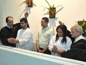 Momento do batismo de Maria Lucia e do marido Geonavi. Um novo recomeço para o casal que espera o nascimento do filho.