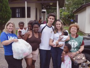 Haitianos recebem alimentos doados na cantata de Natal do IACS