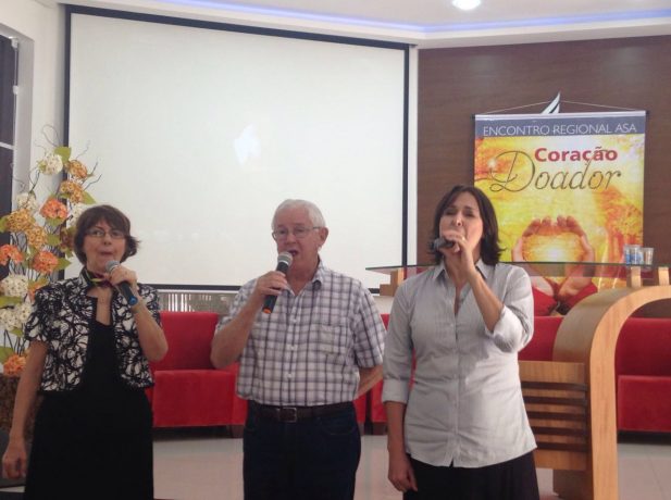Regina Mota canta com os pais durante celebração