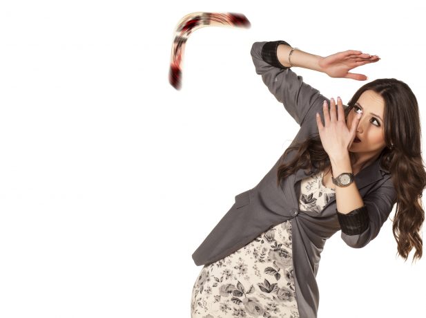 woman defending herself with her hands from the boomerang