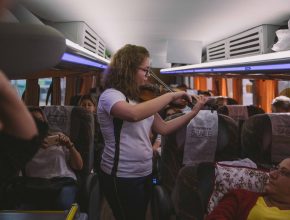 Alunos de Colégio Adventista oram com passageiros de ônibus