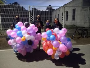Jovens presenteiam comunidade com balões e mensagens de esperança