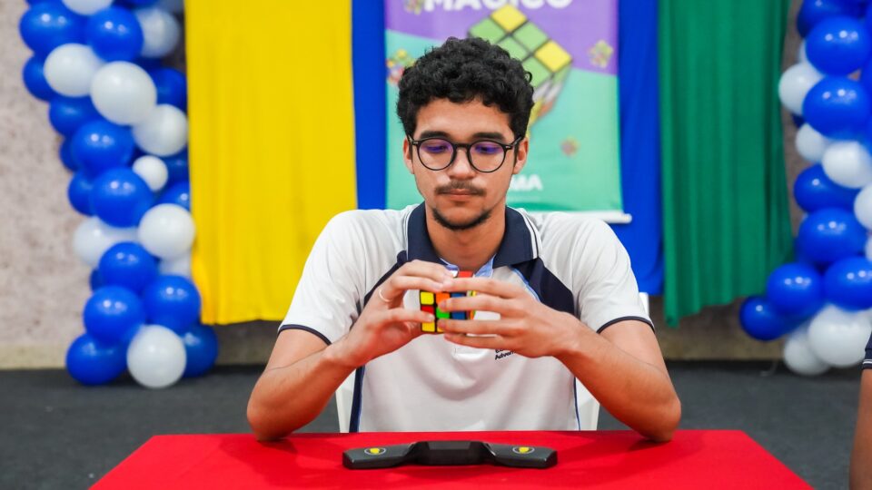 Adolescente olha de forma concentrada para o cubo mágico