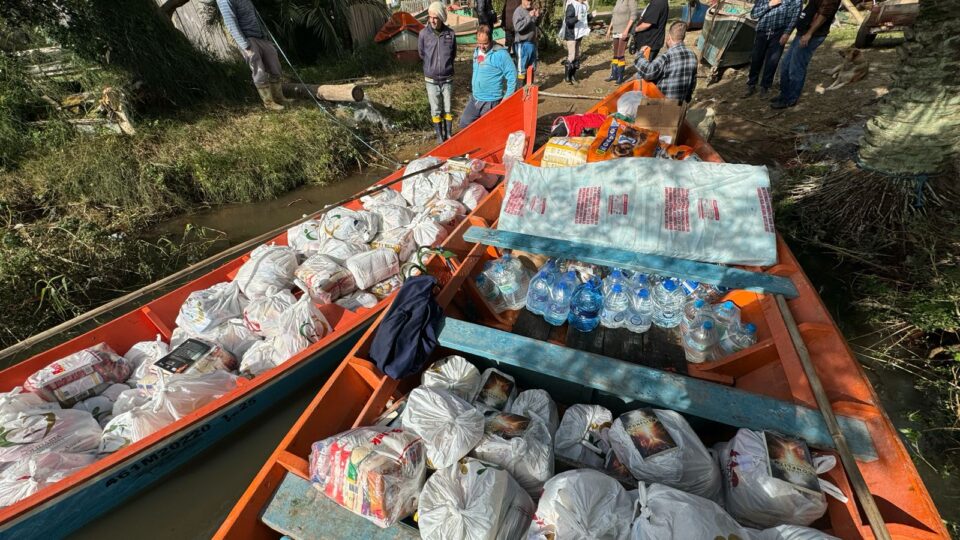Voluntários levam suprimentos de barco para comunidade da Ilha dos Marinheiros, no litoral sul do RS