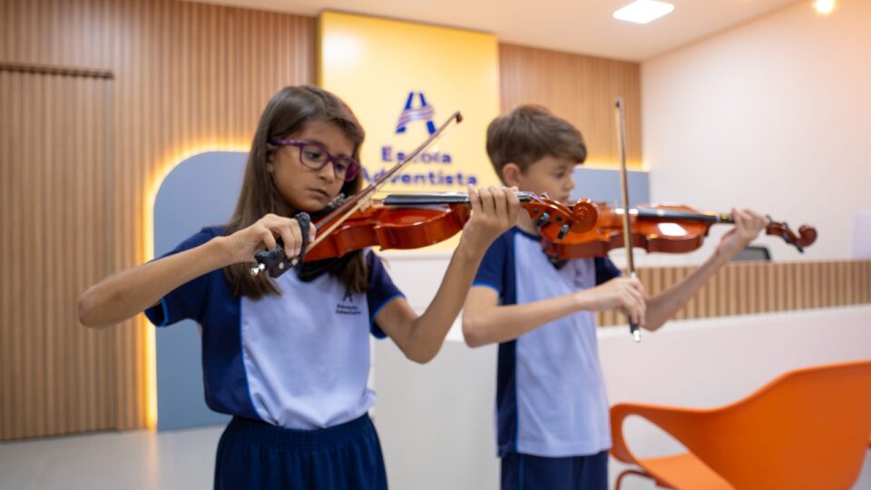 Apresentação de alunos tocando violinos na cerimônia de inauguração.