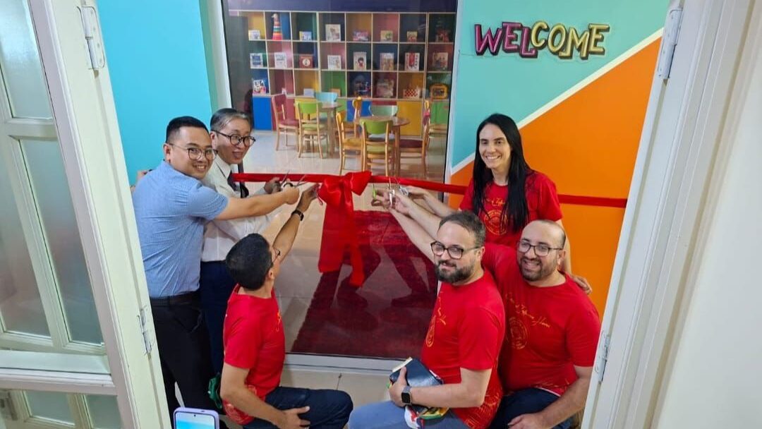 Voluntários reunidos para cortar a faixa de inauguração do novo ambiente do Centro de Influência.