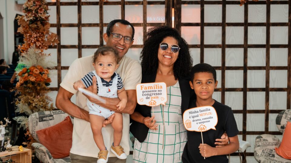 Família posa para foto na entrada do auditório. 
(Foto: Matheus Amaral)