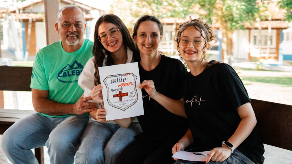 Família posa com o brasão criado em dinâmica. 
(Foto: Matheus Amaral)