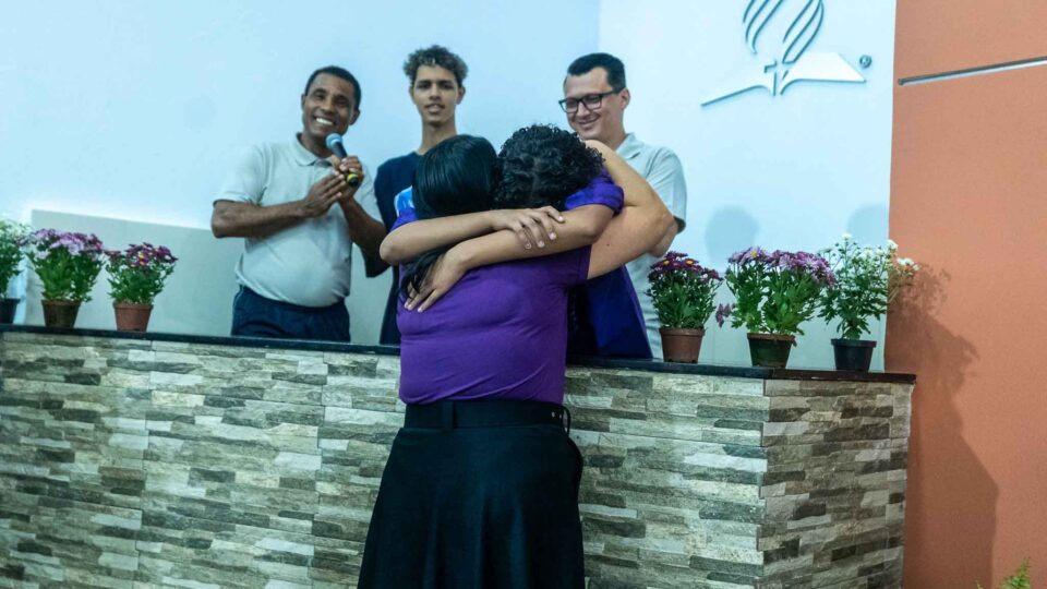 Margarete abraça a adolescente Esther após seu batismo na mobilização feminina nas Igrejas Adventistas (Foto: Renato Semião)