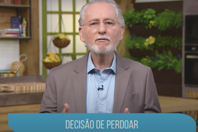 Cesar Vasconcellos, médico psiquiatra, discursando sobre o tema "Decisão de Perdoar" em um cenário que remete a uma cozinha, com plantas ao fundo.